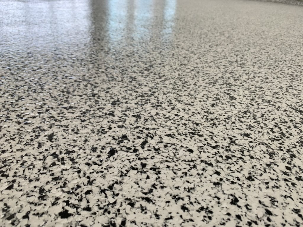 Broadcast vinyl flake locked under a clear polyaspartic topcoat