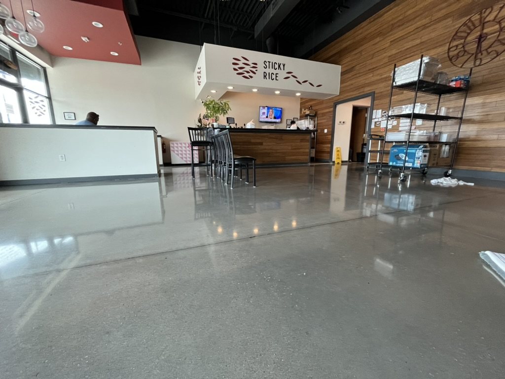 Polished concrete dining room floor in a restaurant, reflecting the counter and lights